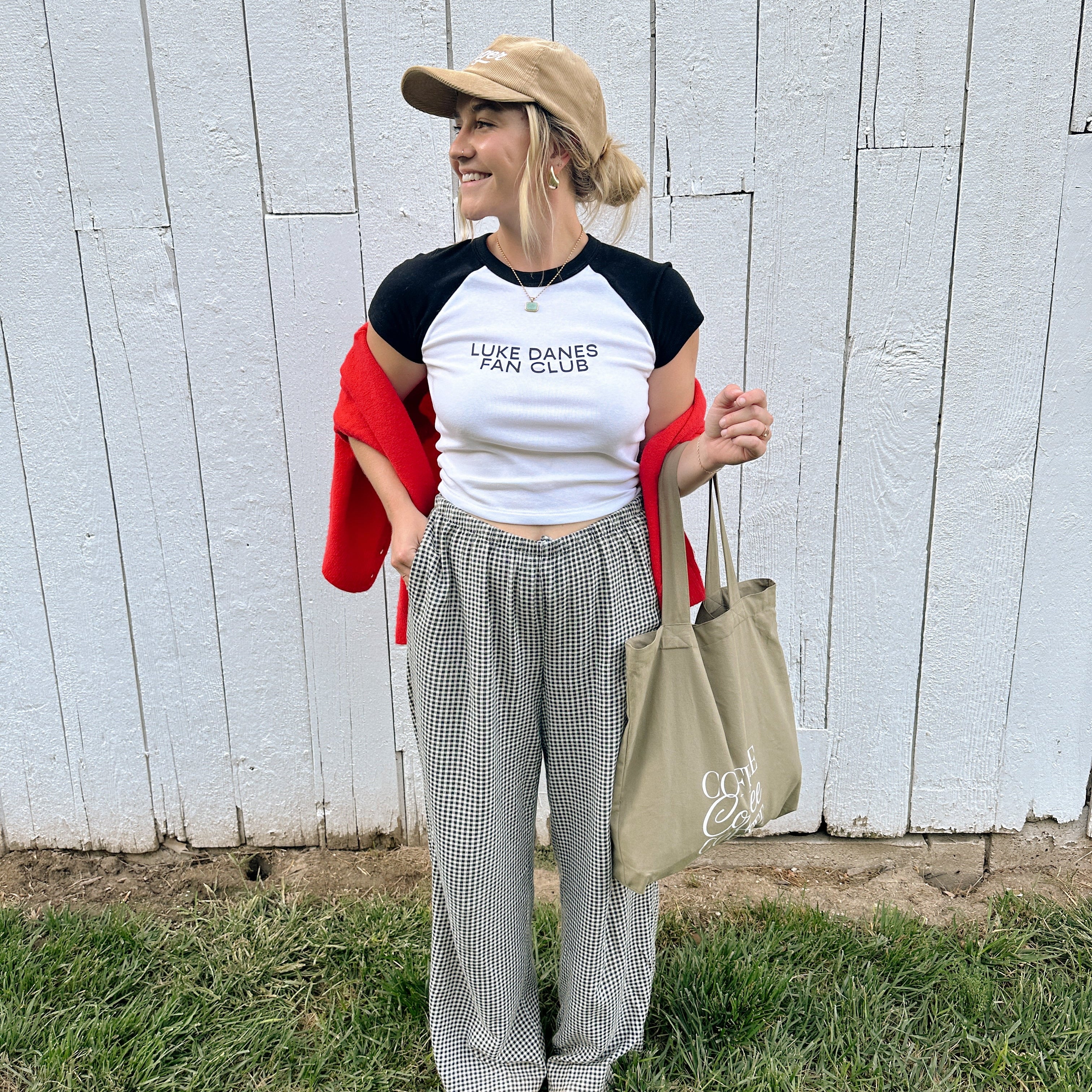 Gilmore Girls merch: model in the Luke Danes Fan Club ribbed tee and cap