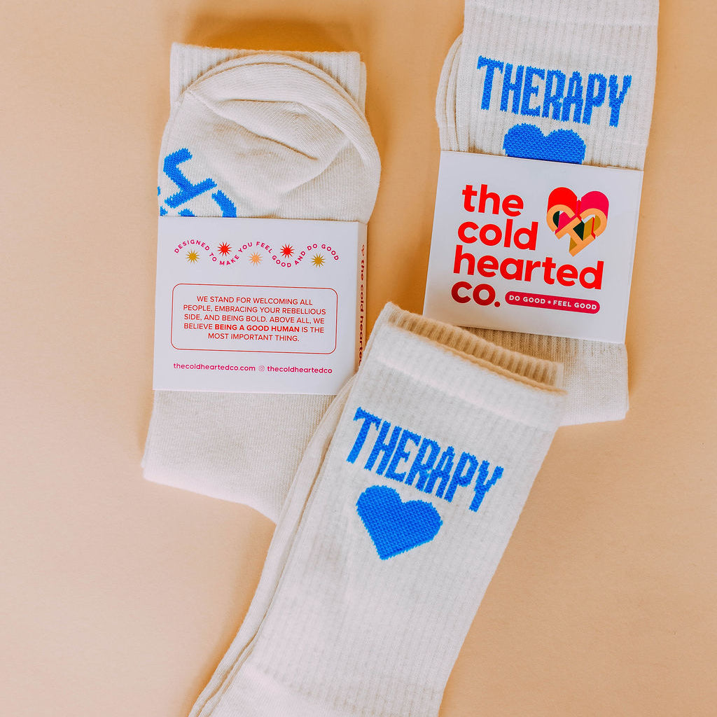 Therapy Socks, cream crew socks with blue Therapy lettering and heart, two pairs in Cold Hearted Co. bands, flat lay