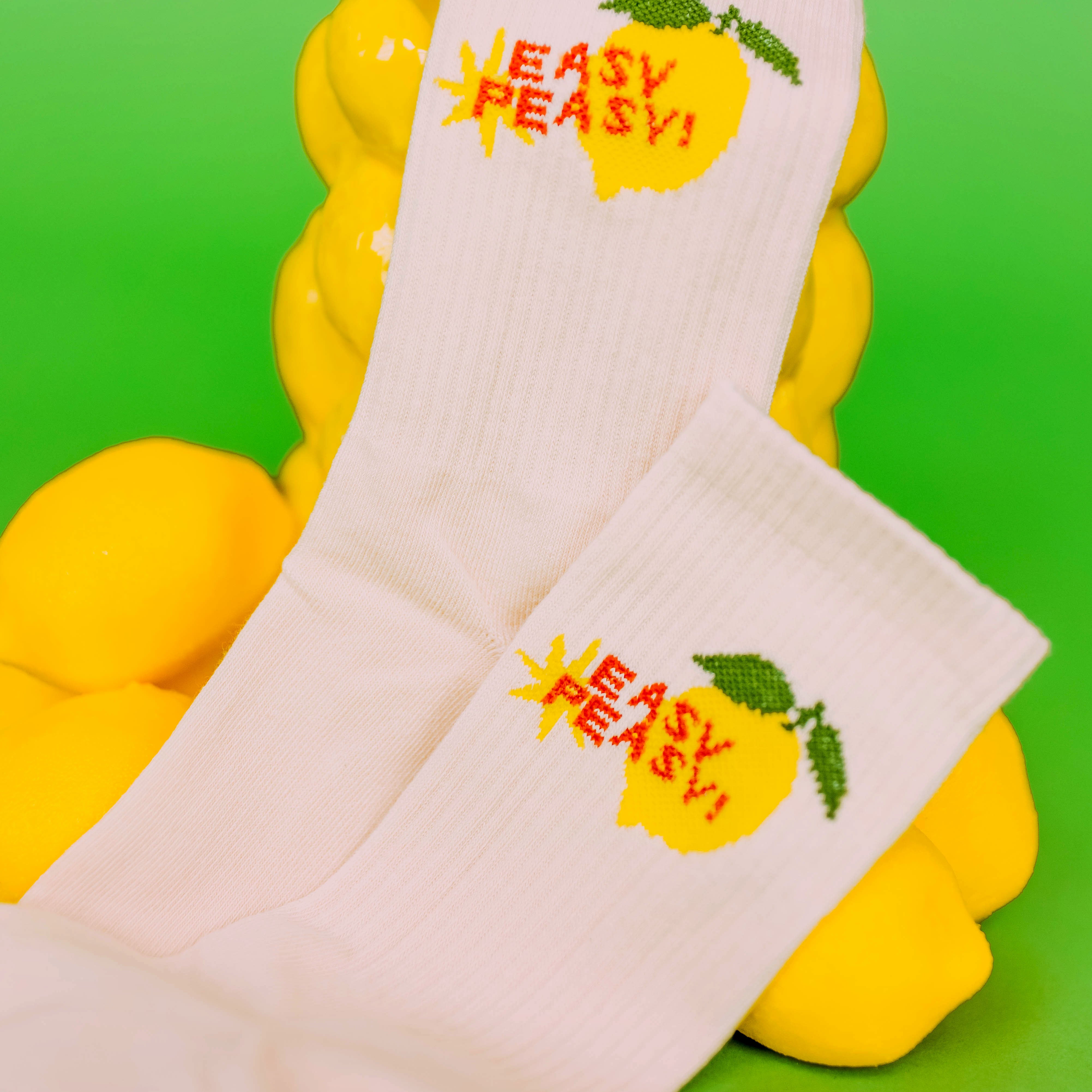 Easy Peasy Lemon Crew Socks, pair of cream socks with a lemon and red Easy Peasy text beside lemons on green