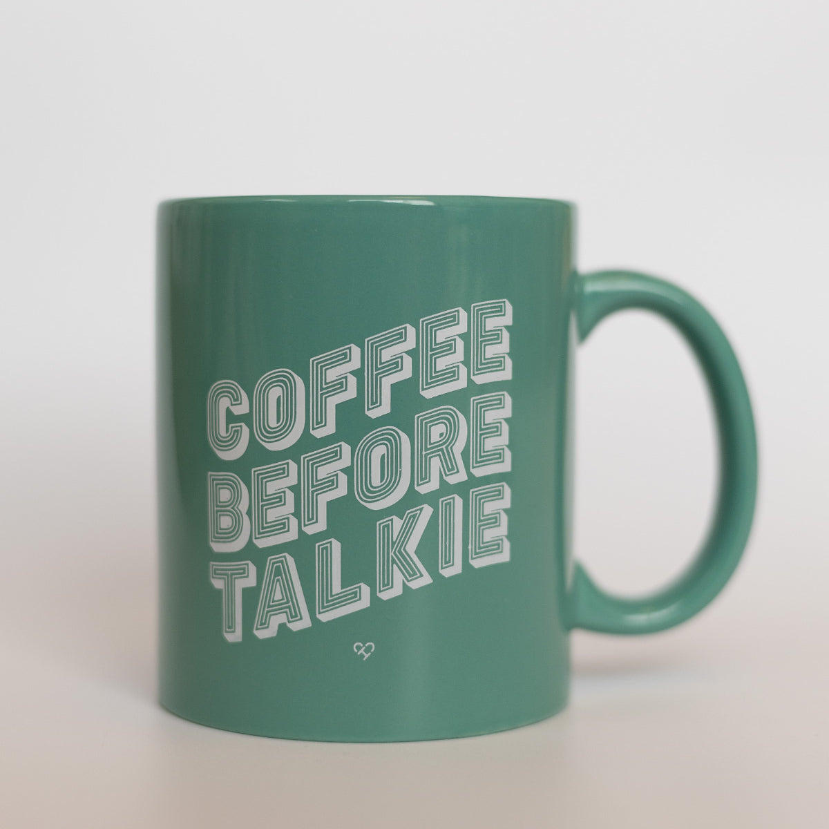 Coffee Before Talkie Mug, sage green ceramic mug with white outlined block lettering on a light backdrop
