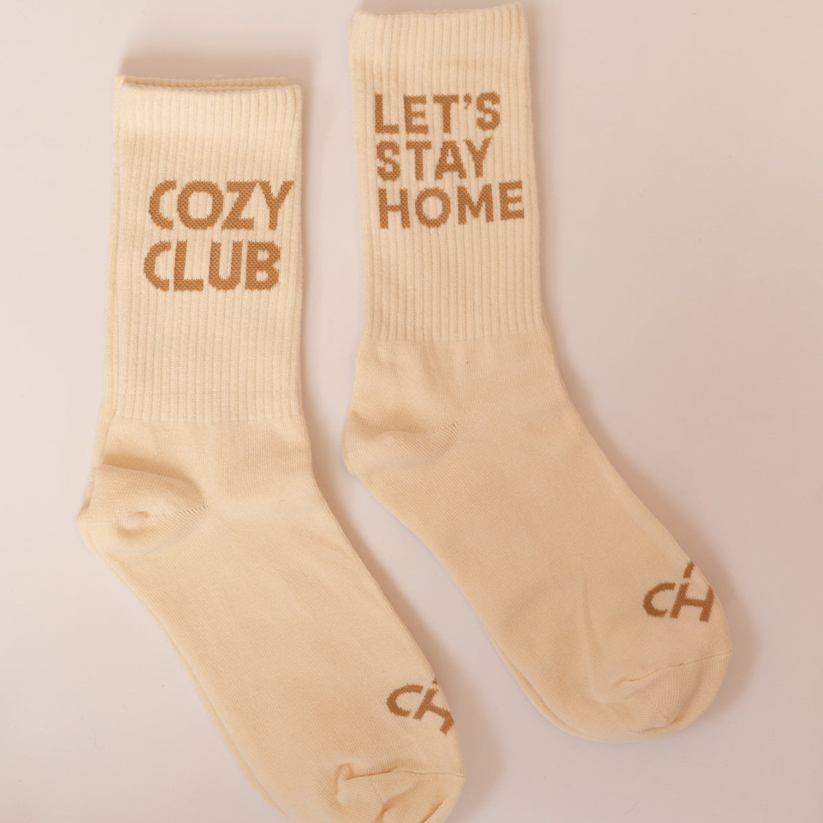 Sock Duo Bundle, cream crew socks side by side, one reading Cozy Club and one reading Let's Stay Home in tan
