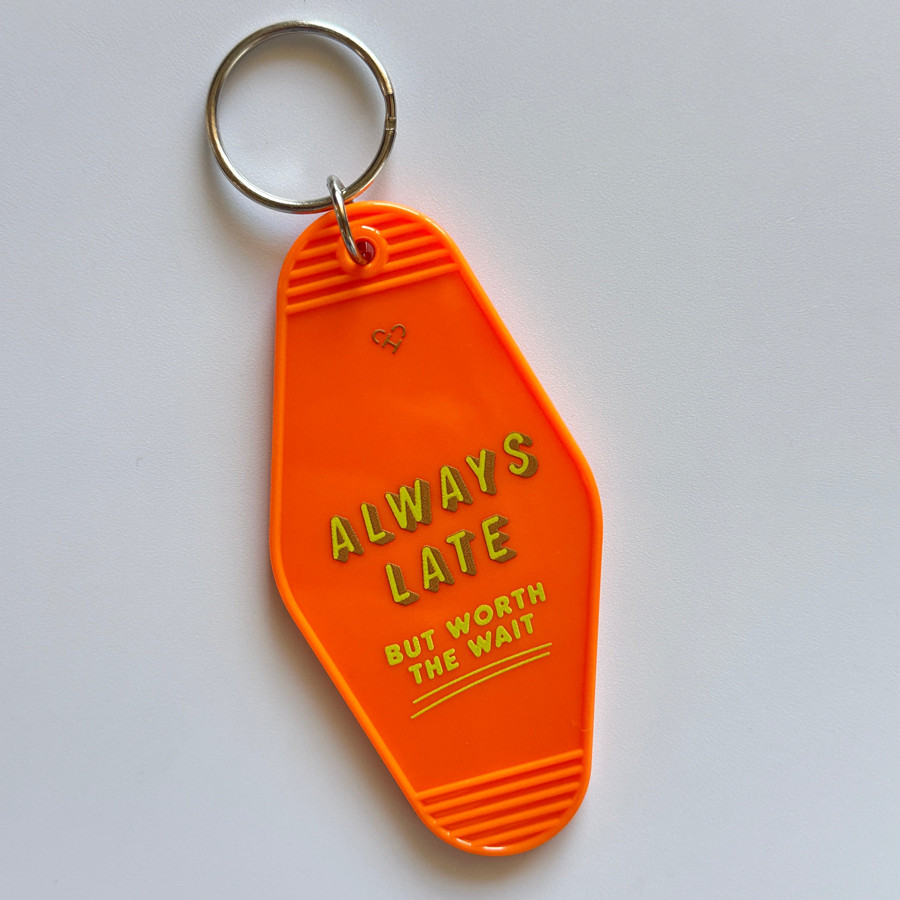 Always Late Motel Keychain, orange motel style key tag reading Always Late But Worth The Wait with silver ring