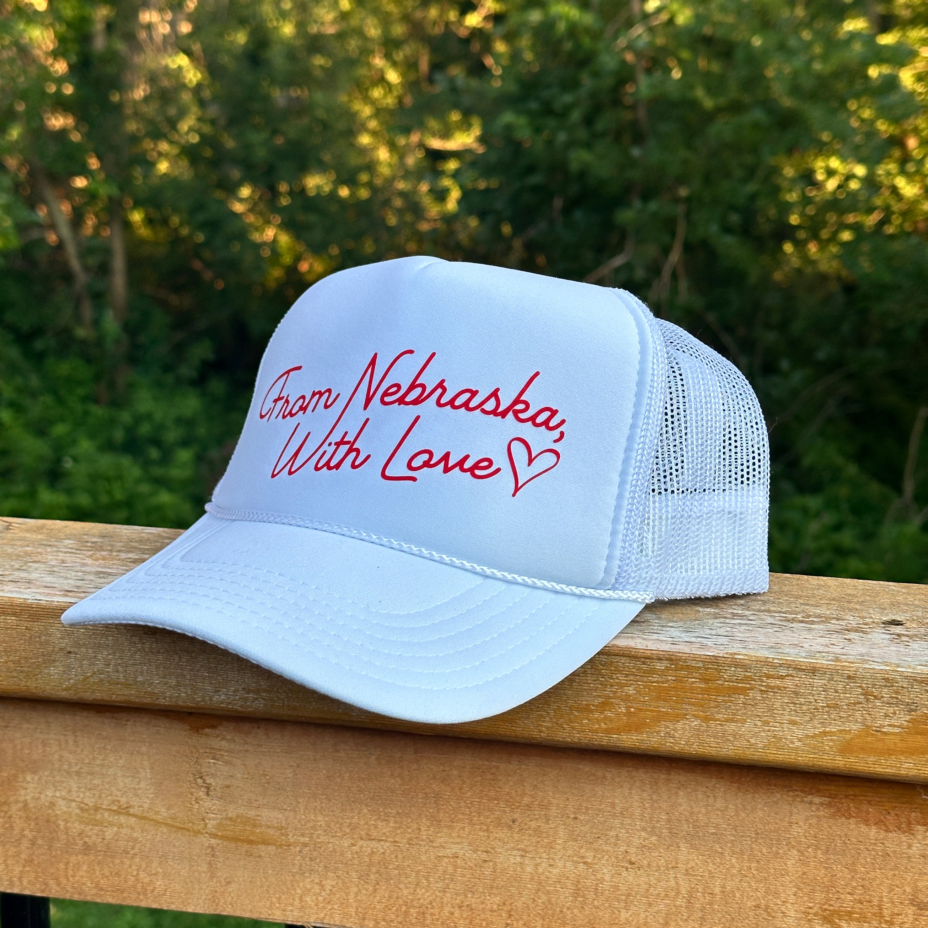 From Nebraska With Love Trucker Hat, white trucker with red script From Nebraska, With Love and heart on a railing