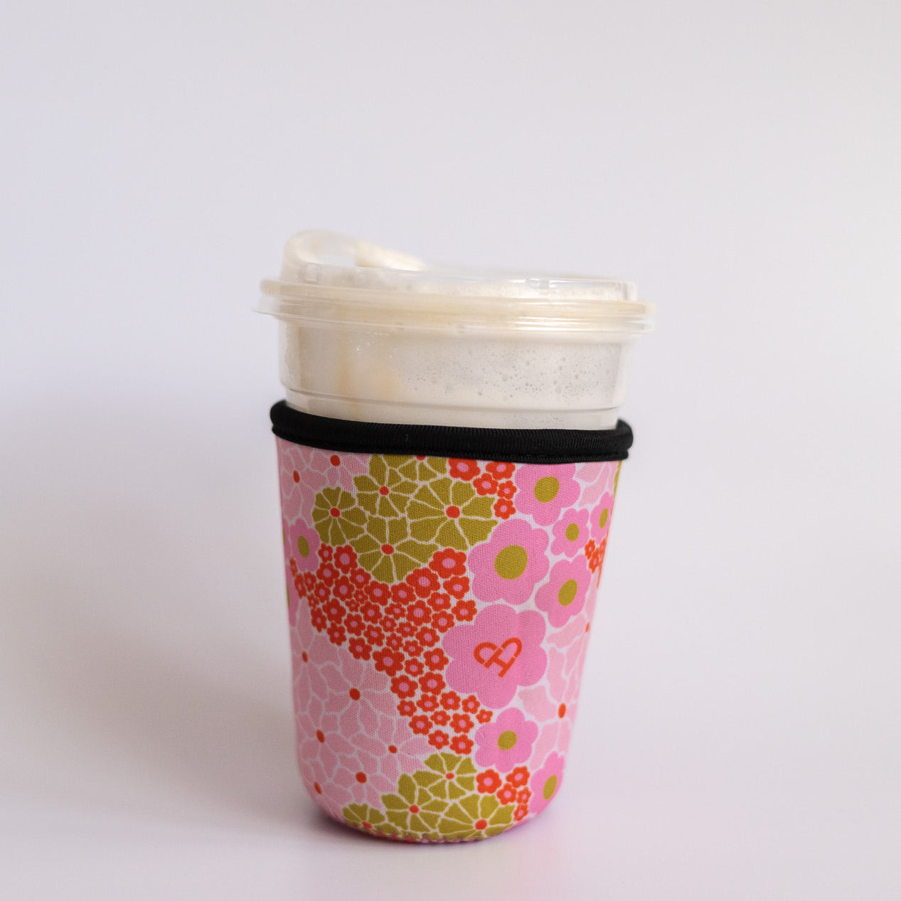 Floral Iced Coffee Sleeve, pink, orange and olive flower print neoprene sleeve with black trim on an iced coffee cup