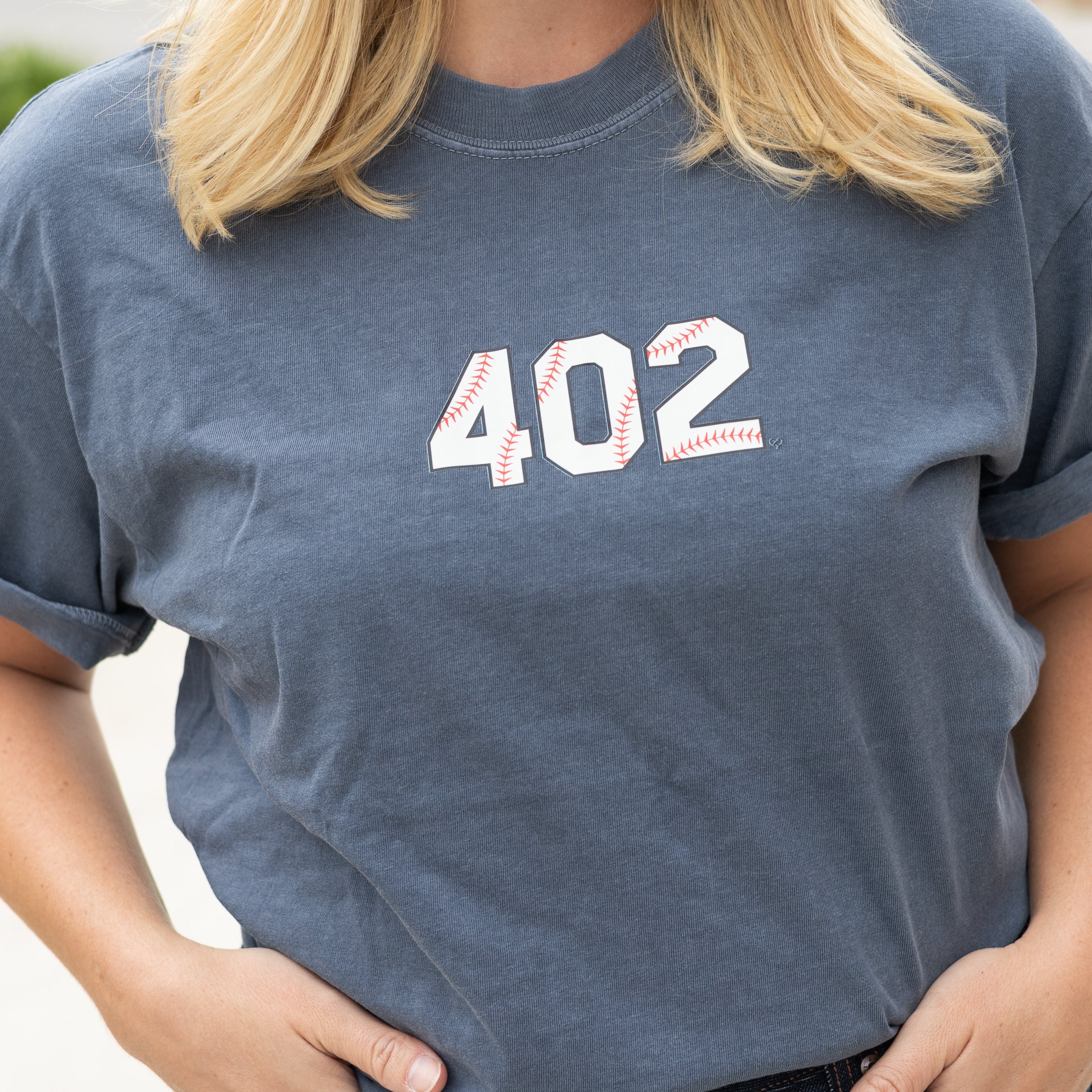 402 Baseball Tee worn by a model, close up of blue gray tee with white 402 baseball stitch numbers on the chest