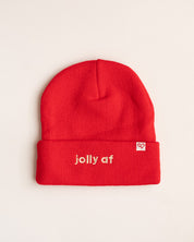 Jolly AF Beanie, red cuffed knit beanie with cream embroidered jolly af lettering and a small heart logo tag