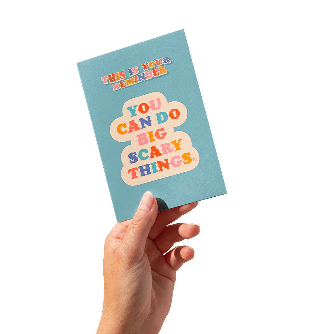 You Can Do Big Scary Things Sticker Card, blue card with This Is Your Reminder and a multicolor sticker, in hand