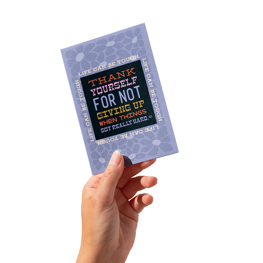 Thank Yourself Sticker Card, lavender floral card reading Life Can Be Tough with a black sticker, in hand