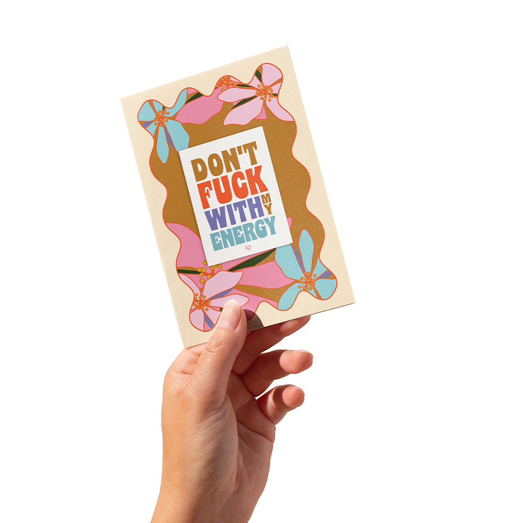 Protect your energy sticker card, cream card with pink and blue floral frame and sticker, held in hand