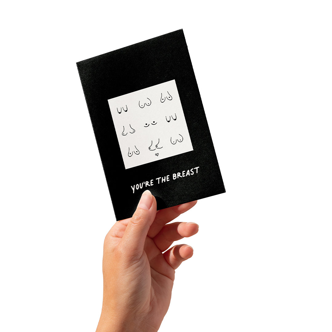 You're The Breast Sticker Card, black card with a boob line drawing sticker, held in a hand on white